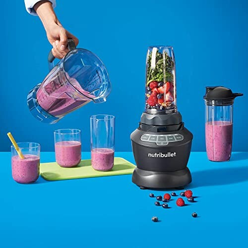 NutriBullet blender with smoothie ingredients and glasses.