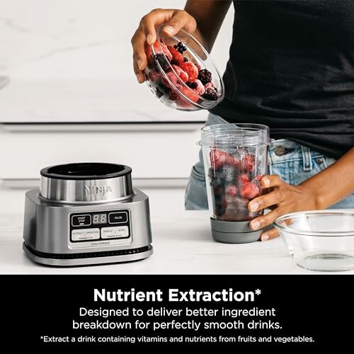 Person adding berries to a blender for nutrient extraction